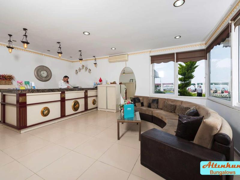 Luminosa hall dell'hotel con reception e accogliente area salotto con grandi finestre.