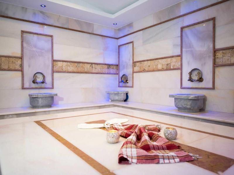 Interiér tradičního hammamu s mramorovými plochami a ručníky.