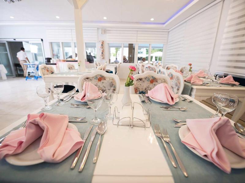 Elegantní snídaňový stůl s růžovými ubrousky v jasném, moderním prostředí.