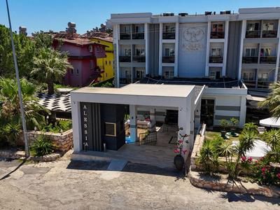 Complejo hotelero moderno con abundante vegetación y fachada clara y luminosa a la luz del día.