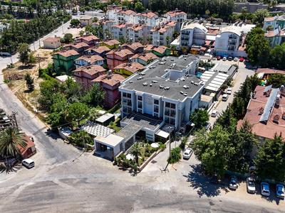 Vista aérea de un complejo hotelero con carreteras circundantes y vegetación en una zona soleada.