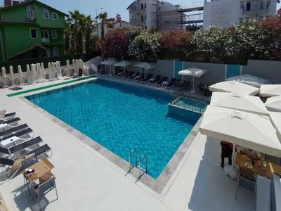 Piscina exterior moderna con tumbonas y sombrillas en un entorno hotelero.