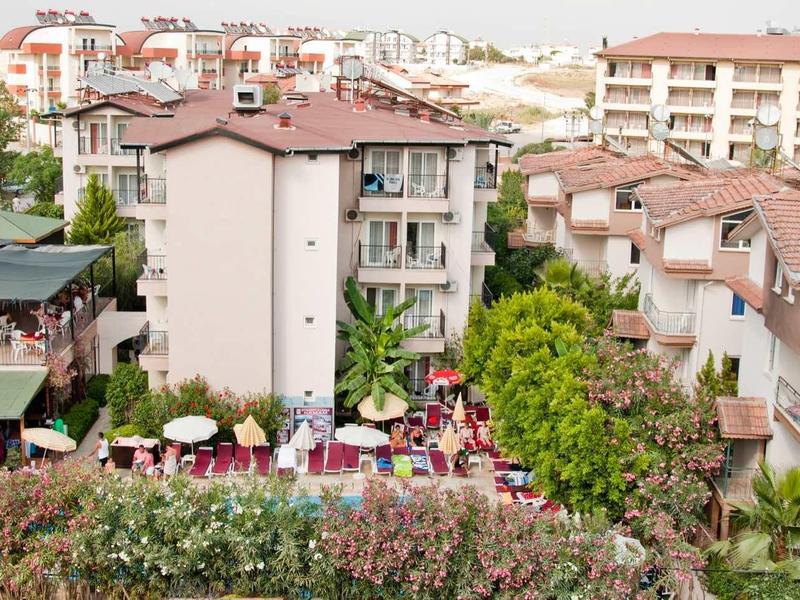 Vista di un complesso alberghiero con più edifici e piscine all'aperto in una zona collinare.