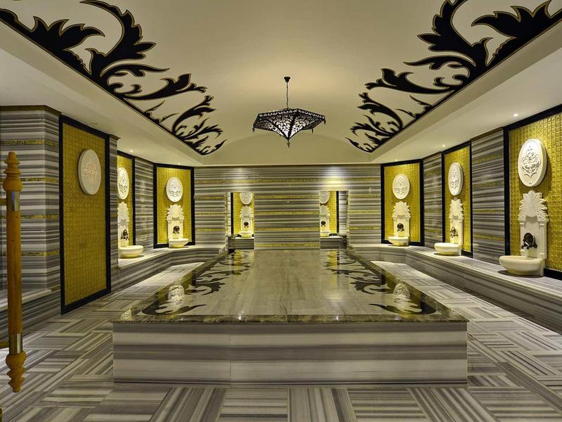 Luxusní spa místnost s sochami a elegantní černobílou výzdobou.