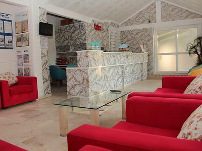 Bright hotel lobby with red armchairs and marble reception desk
