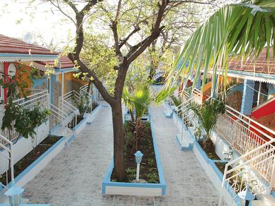 Hotel courtyard with a tree in the center and room entrances on both sides