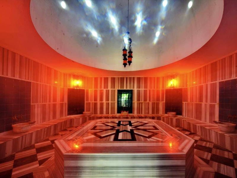 Modern sauna room with bright marble and ambient lighting.