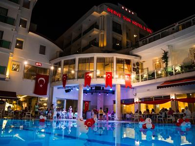 Hotel met verlicht zwembad en buitenruimte 's nachts