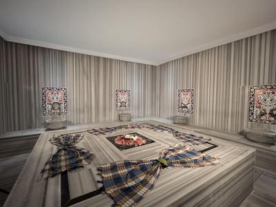 Een traditionele Turkse badhuis (Hamam) met marmeren muren en liggende stenen in een rustige kamer.