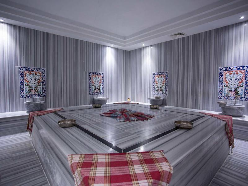 Elegancki turecki hammam z szarymi marmurowymi ścianami i zdobionymi płytkami.