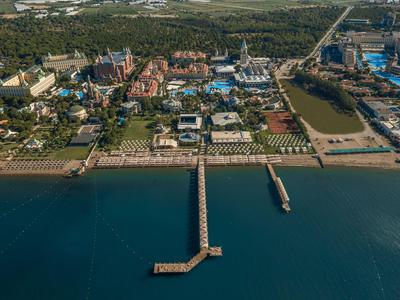 Vista aerea di una spiaggia con un molo, ombrelloni e hotel sullo sfondo