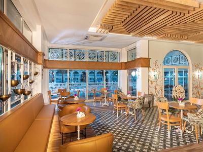 Licht, elegant restaurant met bruine leren stoelen en artistieke betegelde vloeren.