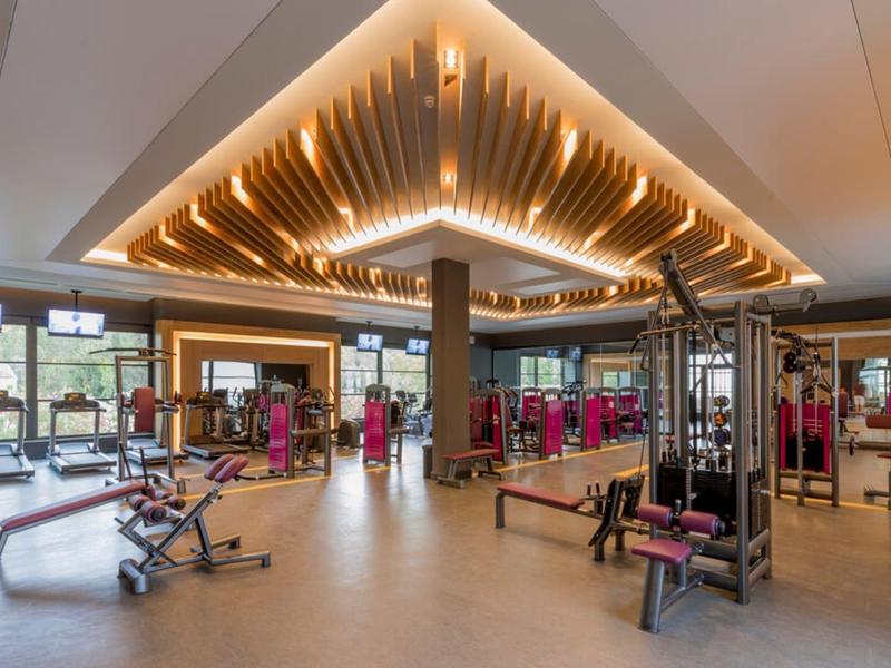 Goed verlichte sportschool met moderne apparatuur en grote ramen