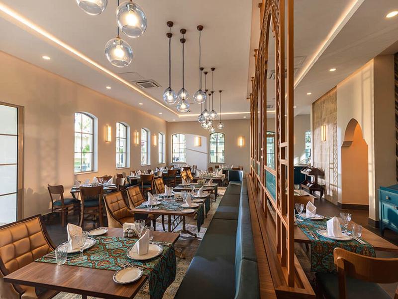 Licht, modern restaurant met stijlvolle tafels, stoelen en grote ramen.