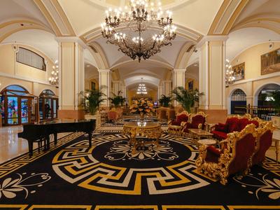 Luxuriöse Hotellobby mit eleganten Möbeln, Kronleuchtern und prächtigem Teppichboden.