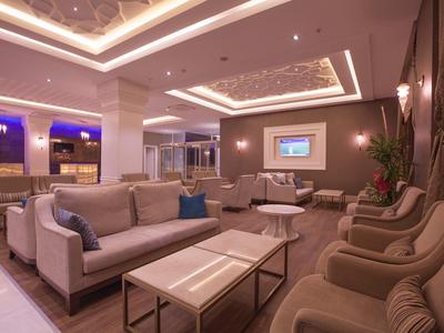 Salon d'hôtel élégant avec canapés confortables, fauteuils et éclairage moderne.