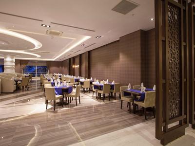 Restaurant d'hôtel moderne avec espace repas assis et éclairage élégant.