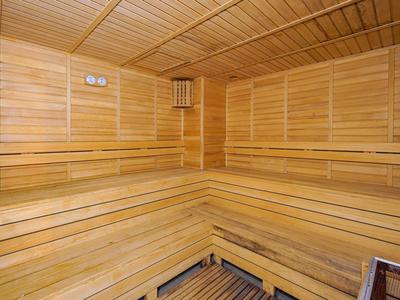 Sauna en bois avec bancs d'assise en gradins et panneaux muraux en bois.