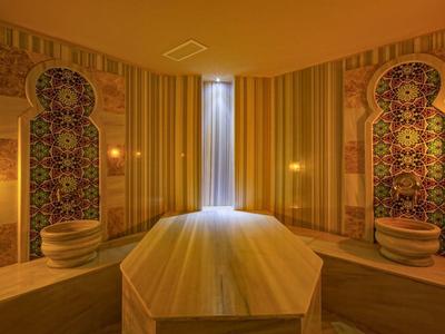 Espace bien-être de style oriental luxueux avec une ambiance calme et un éclairage chaud.