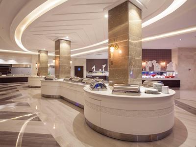 Espace buffet moderne avec comptoirs blancs incurvés et éclairage élégant.