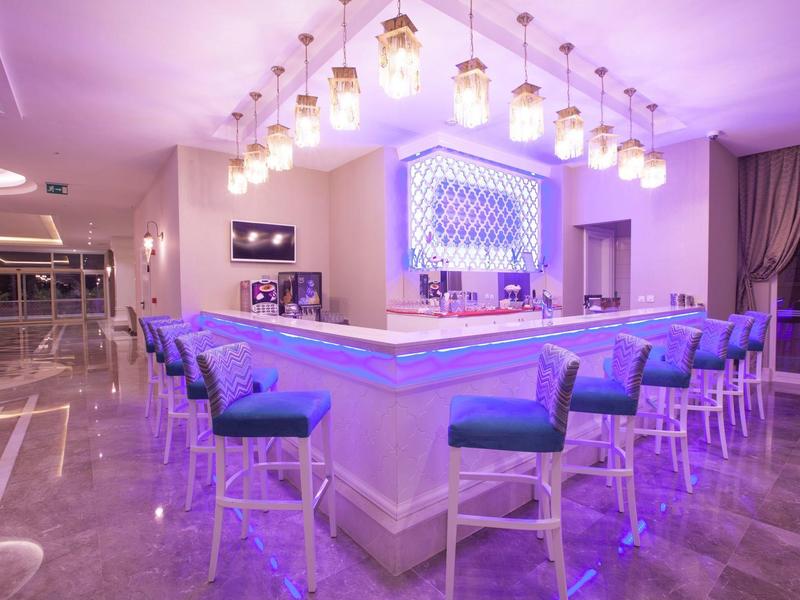 Bar moderne avec éclairage bleu et tabourets confortables dans un hôtel.