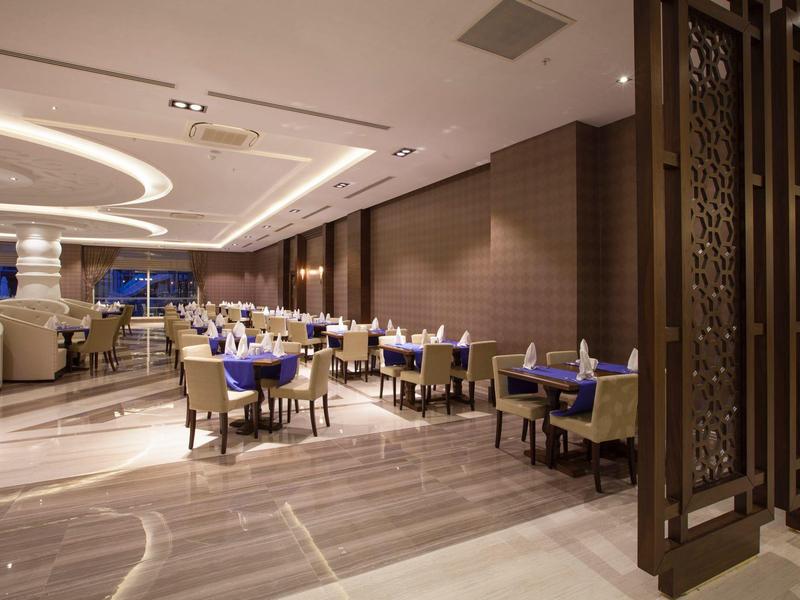 Restaurant d'hôtel moderne avec espace repas assis et éclairage élégant.