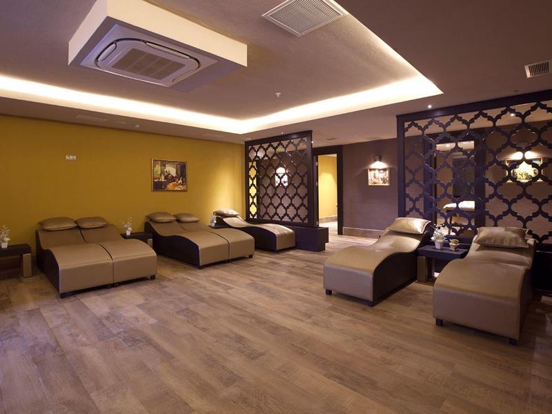 Grand hôtel avec piscine, entouré de verdure et au coucher du soleil.