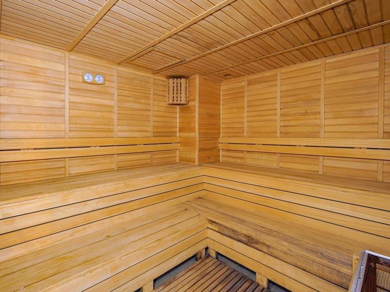 Sauna en bois avec bancs d'assise en gradins et panneaux muraux en bois.