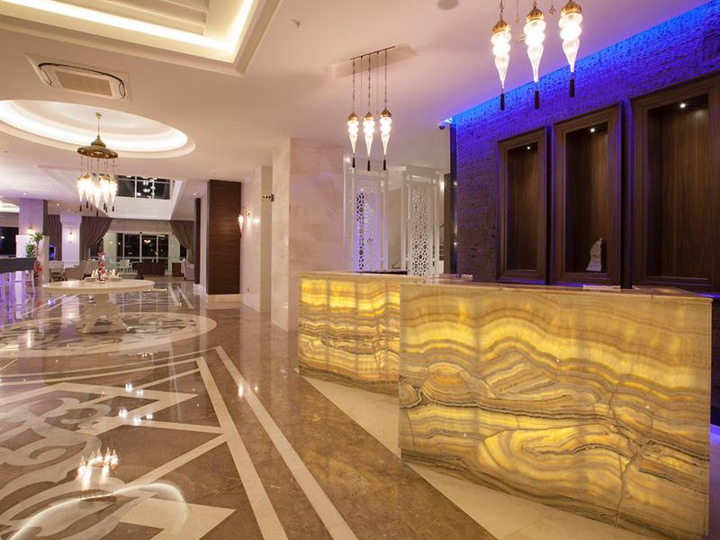 Hall d'hôtel moderne avec comptoir en marbre éclairé et ambiance élégante.
