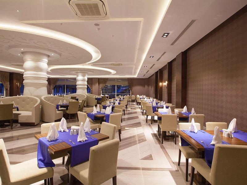 Restaurant moderne avec nappes bleues, chaises confortables et éclairage élégant.