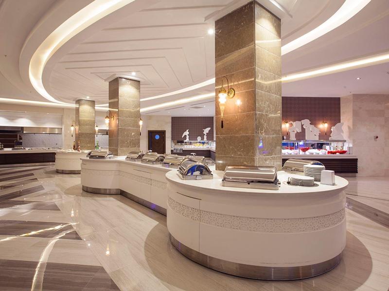 Espace buffet moderne avec comptoirs blancs incurvés et éclairage élégant.