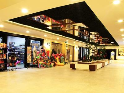 Ruimtelijk winkelgebied in een hotel met winkels, zitplaatsen en heldere verlichting.