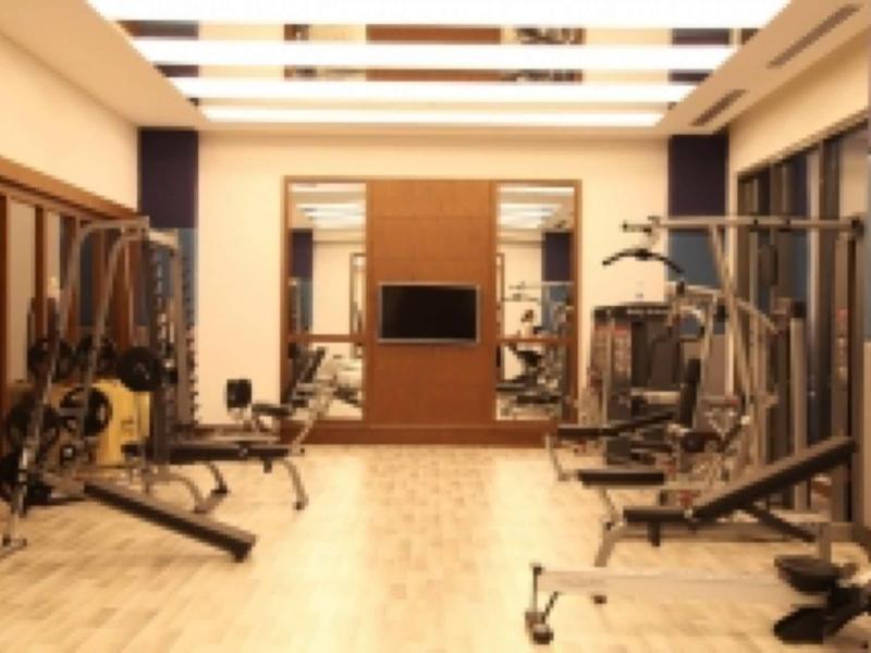 Goed uitgeruste fitnessruimte met moderne fitnessapparaten en houten vloer