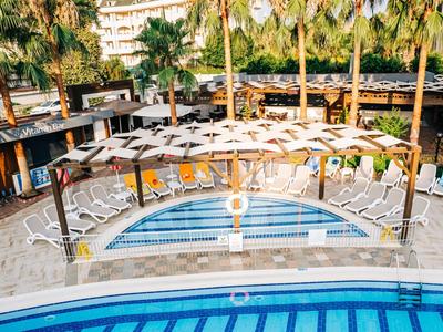 Słoneczny basen z leżakami i parasolami w tropikalnym kurorcie.