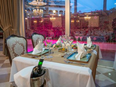 Mesa de comedor elegante en restaurante de hotel con cubiertos finos y vista a la terraza.
