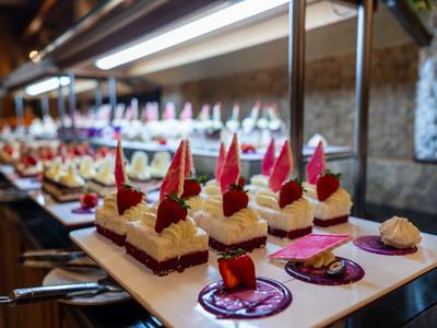 Piatto elegante di dessert con mousse di cioccolato e frutti di bosco in un ambiente ristorante.