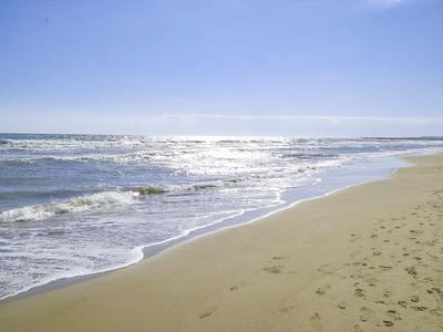 Plaża z delikatnymi falami i czystym niebem, idealna na relaksujące wakacje.