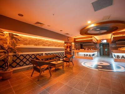 Lobby moderna dell'hotel con reception spa, illuminazione elegante e aree salotto confortevoli.