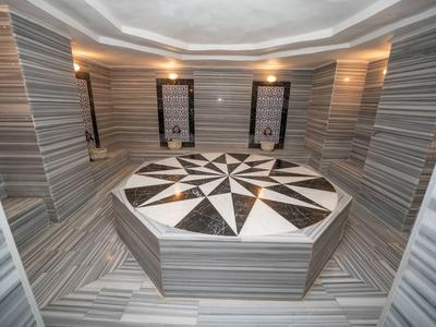 Área de bienestar de diseño moderno con columna central de mármol y elegantes luces de pared.