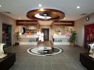 Nowoczesna lobby hotelowa z recepcją, barem spa i miejscem do siedzenia w ciepłych kolorach.