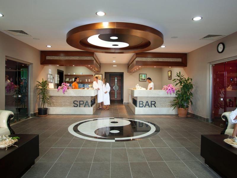 Nowoczesna lobby hotelowa z recepcją, barem spa i miejscem do siedzenia w ciepłych kolorach.