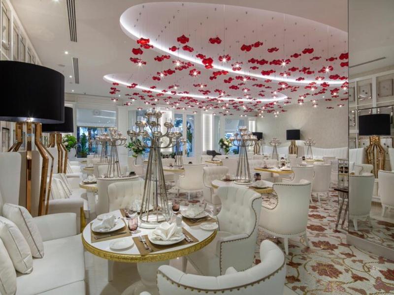 Eleganckie wnętrze restauracji hotelowej z nowoczesnym wystrojem i czerwonymi lampami.