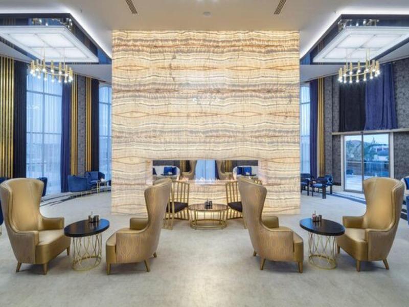 Elegancki salon z beżowymi skórzanymi fotelami i nowoczesnymi lampami.