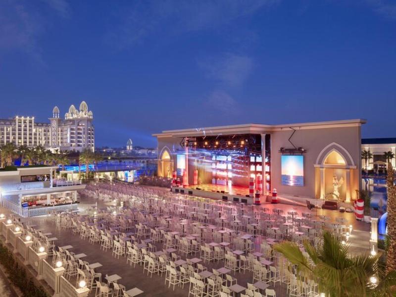 Nocny widok sceny na zewnątrz z ustawionymi krzesłami w luksusowym hotelu.