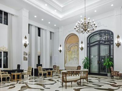 Eleganter Hotel-Lobbybereich mit Kronleuchter, klassischen Möbeln und großem Fenster