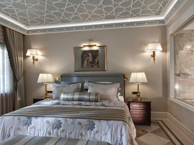 Bequemes Schlafzimmer mit Doppelbett, Nachttischen, Lampen und dekorativem Wandbild.