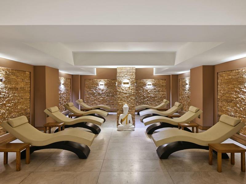 Entspannungsraum mit Wellnessliegen und warmem Beleuchtungskonzept in einem Hotel.