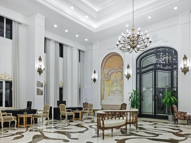 Eleganter Hotel-Lobbybereich mit Kronleuchter, klassischen Möbeln und großem Fenster