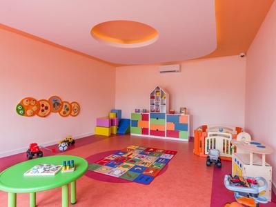 Colorful children's playroom with tables, toys, building blocks, and carpet in a hotel.