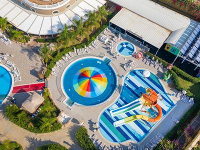 Aerial view of a hotel pool with colorful water features, slides, and lounge chairs.
